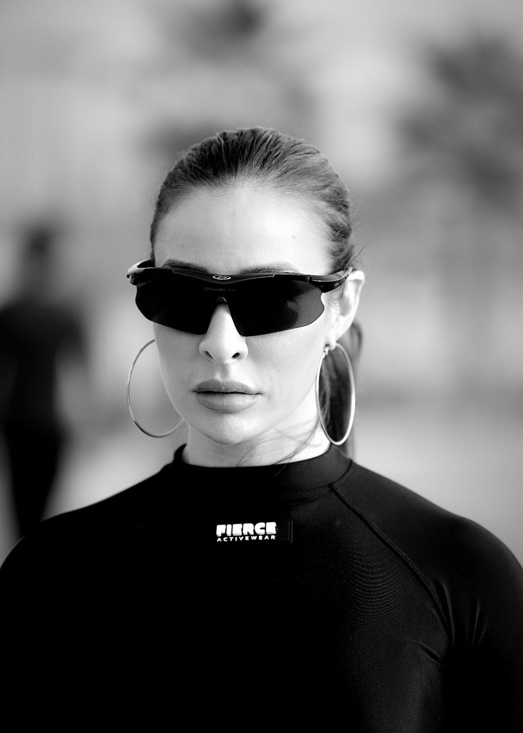 Black and white photo of a person wearing sunglasses and hoop earrings with 'Fierce' clothing brand visible.