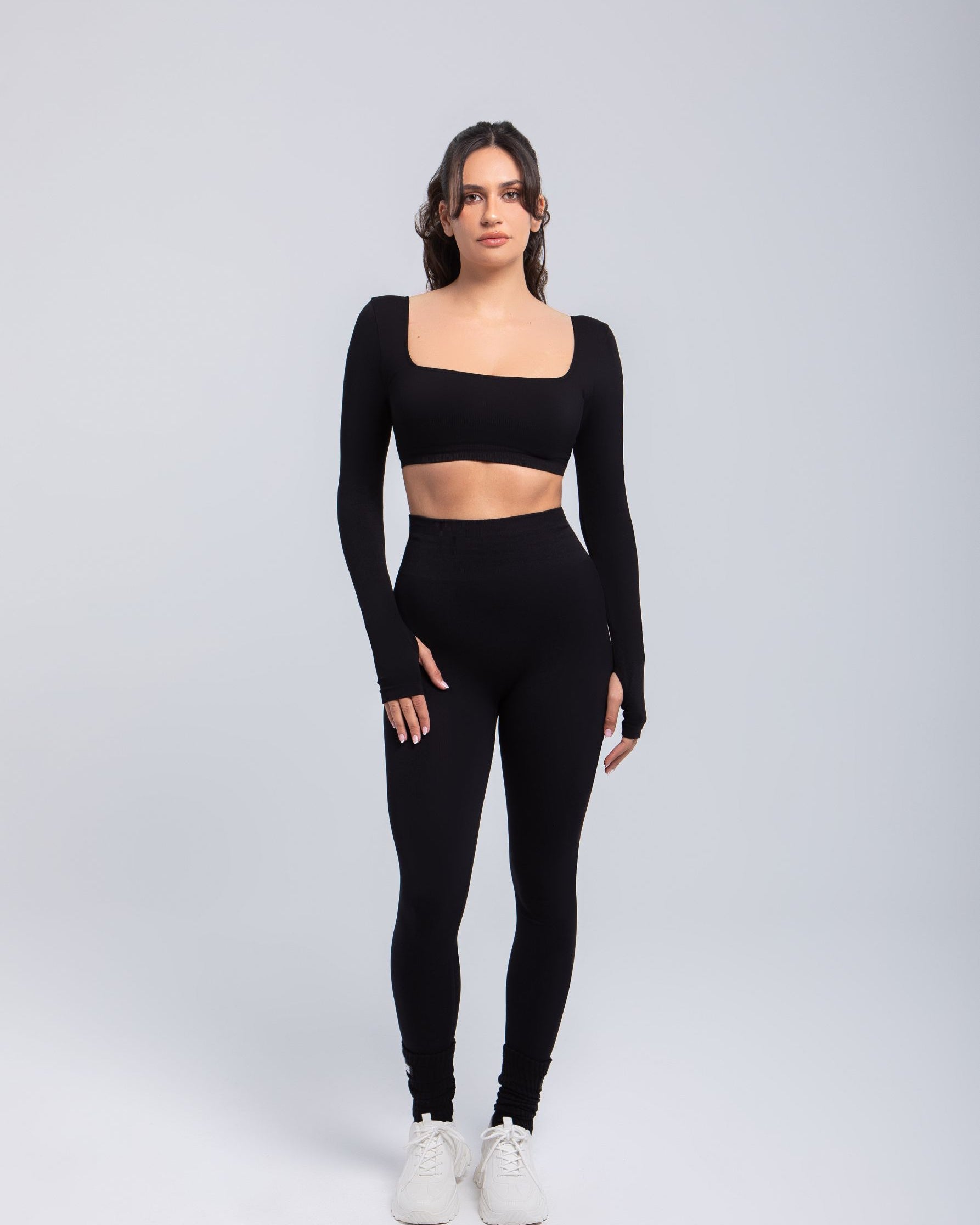 Full body view of model wearing Second Skin sculpt push-up long sleeve bra in Black with high-waist leggings