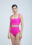 Woman wearing a bright pink Fierce swimsuit on a white background