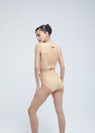 Woman wearing a beige Fierce bodysuit on a white background