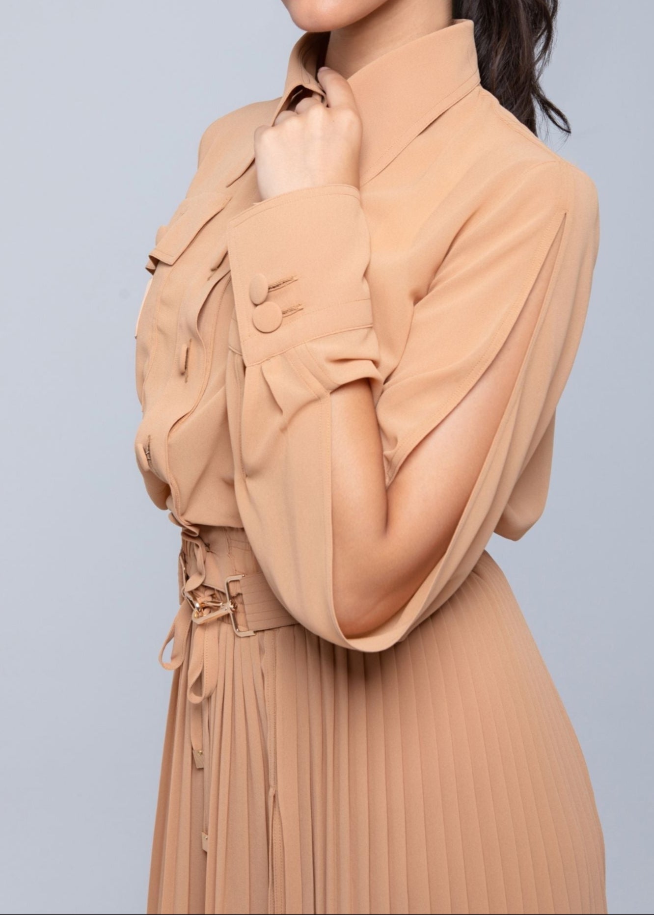 Woman wearing a Fierce beige dress against a gray background