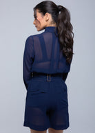 Model facing away, wearing a Fierce sheer navy blue long-sleeve shirt tucked into matching high-waisted shorts with back pockets and a belt