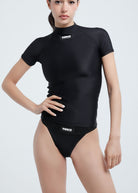 This image displays the Fierce IMAN ANTI-UV COMPRESSIVE SHORT SLEEVE TOP, designed specifically for active women. The top, showcased in a versatile black color, features a high neck and short sleeves, providing both UV protection and a stylish modern look.