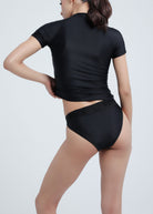 Person wearing a black Fierce swimsuit on a light gray background