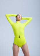 Person wearing a bright yellow Fierce swimsuit with a belt on a light gray background