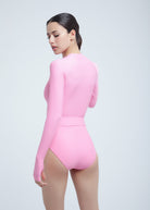 Woman wearing a pink Fierce bodysuit on a light gray background