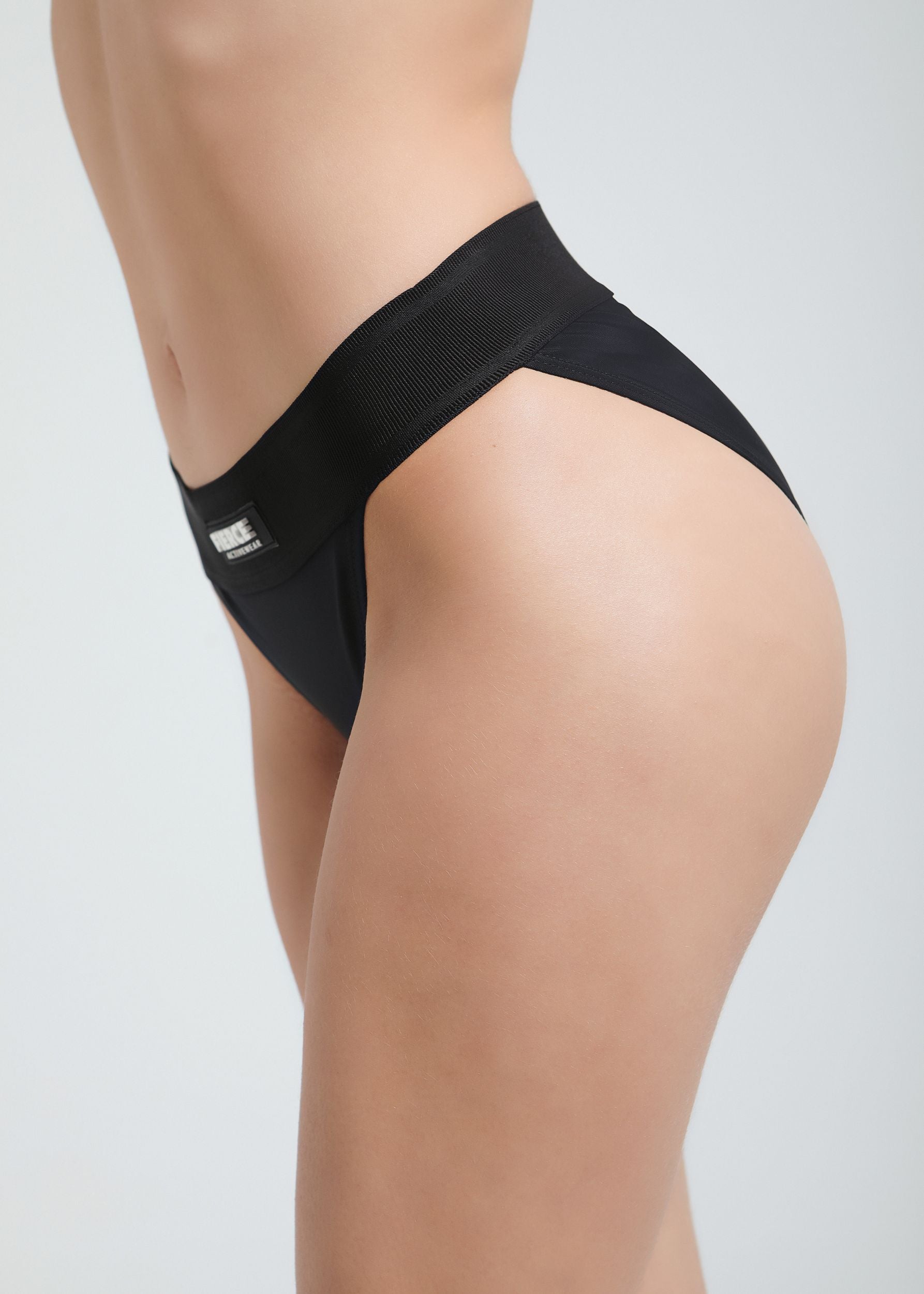 This image features the Fierce SERENA LOW WAIST BOTTOM, a stylish and comfortable women's swimwear piece. The bottom is crafted in a classic black color, emphasizing its universal appeal and versatility.