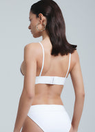 Back view of a woman wearing Fierce Activewear's white Serena bikini set, featuring a triangle top with adjustable straps and a high-cut bikini bottom