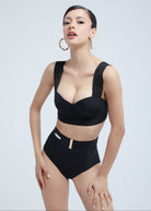 Woman wearing a black Fierce bikini set on a light gray background