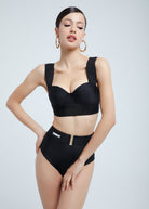 Woman wearing a Fierce black bra and high-waisted underwear on a plain background
