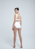 Woman wearing a white Fierce bikini on a plain background