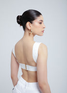 Woman wearing a white Fierce top with an open back design.
