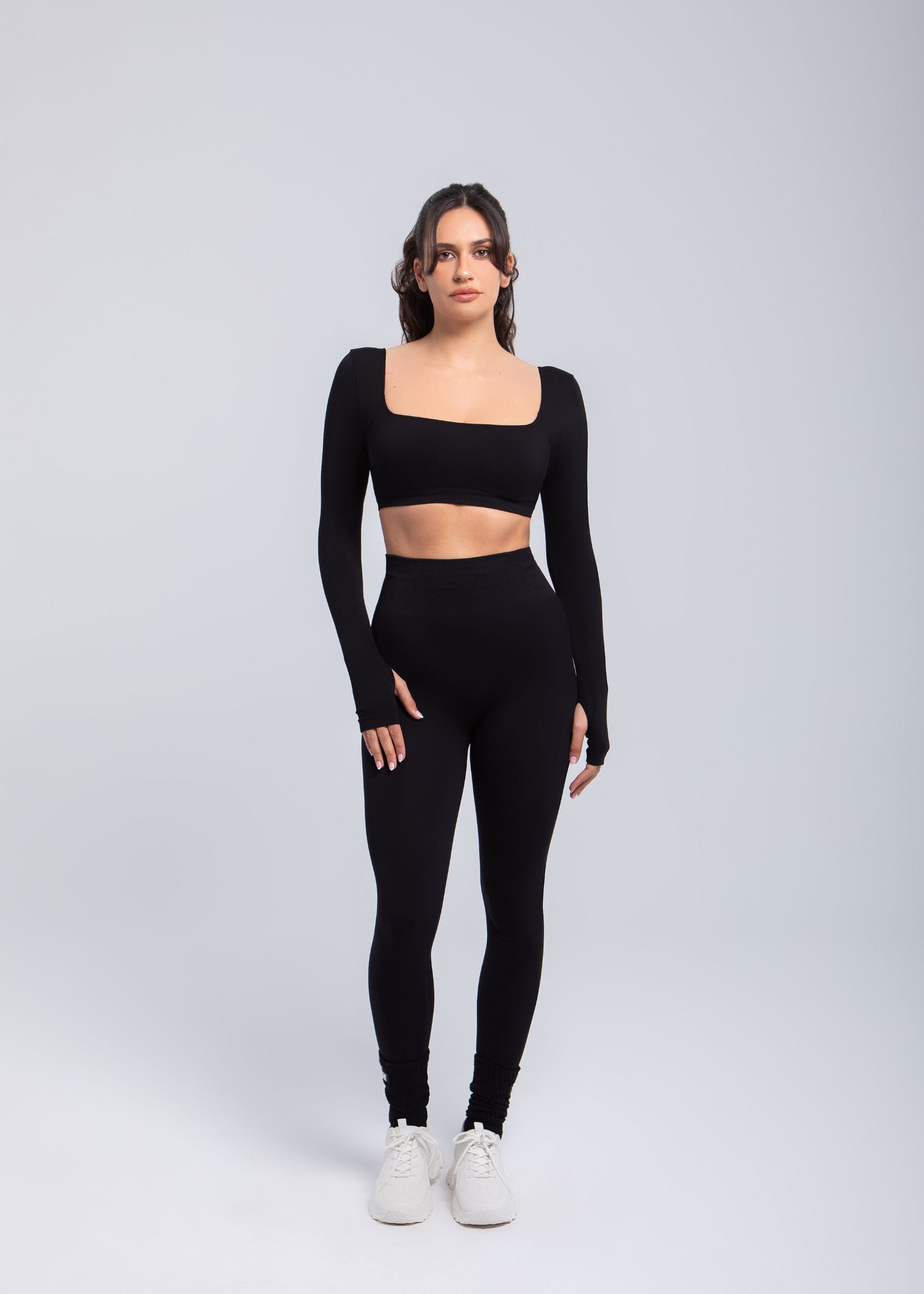 Full body view of model wearing Second Skin sculpt push-up long sleeve bra in Black with high-waist leggings
