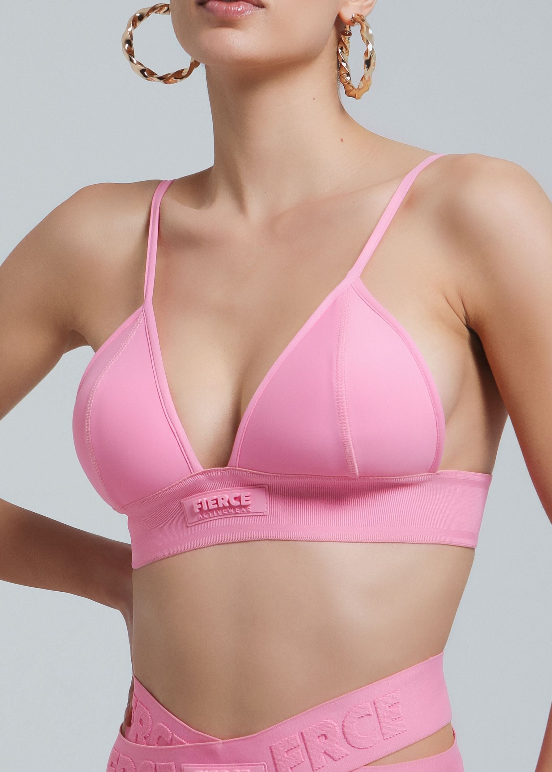 Close-up of a woman wearing the Fierce Activewear Serena triangle bikini top in pink, featuring a supportive underband and adjustable straps